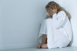 woman sitting on the ground wonders if she's experiencing ptsd triggers