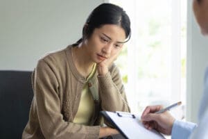 woman talks with provider holding a checklist about how to find a psychiatrist in boston